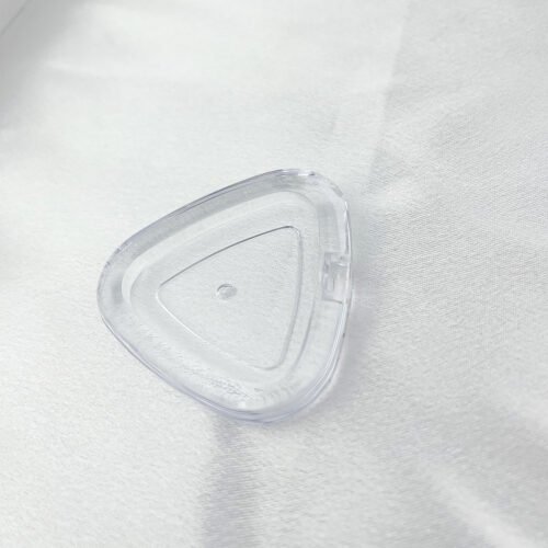 Top view of rounded triangle transparent empty cosmetic compact case on white fabric background