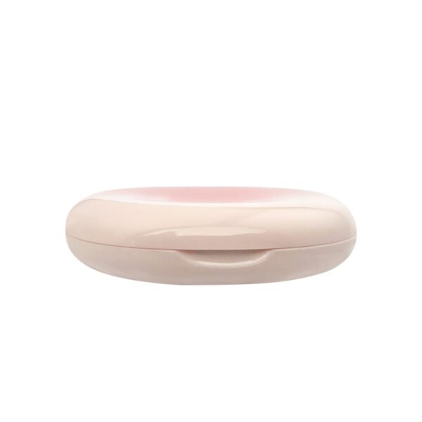 Side profile view of closed glossy gradient pink off-white oval powder compact with front push latch